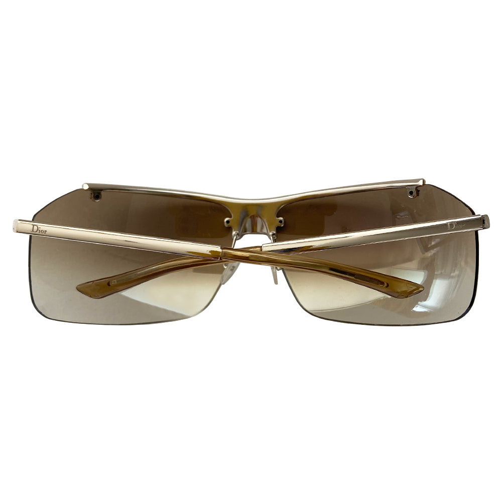 Christian Dior HIT 2 frameless sunglasses with curved charcoal color lens and logo engraved silver-tone metal bridge, crystal embellished upper frame edge, Dior engraved arms, and nose bridge. Made in Italy.