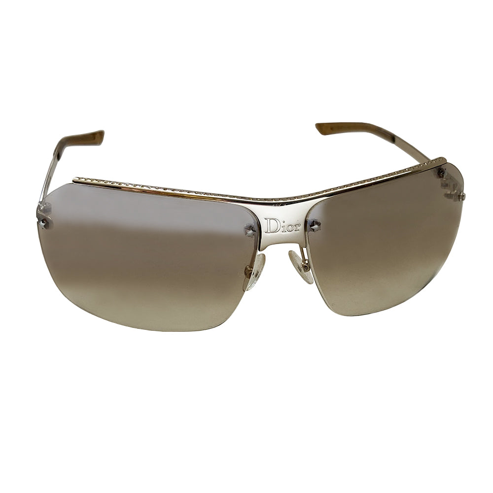 Christian Dior HIT 2 frameless sunglasses with curved charcoal color lens and logo engraved silver-tone metal bridge, crystal embellished upper frame edge, Dior engraved arms, and nose bridge. Made in Italy.