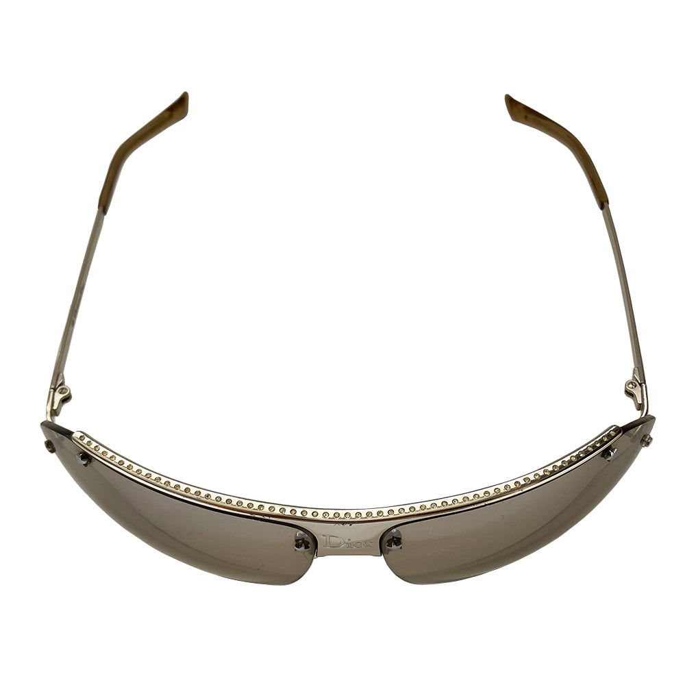 Christian Dior HIT 2 frameless sunglasses with curved charcoal color lens and logo engraved silver-tone metal bridge, crystal embellished upper frame edge, Dior engraved arms, and nose bridge. Made in Italy.