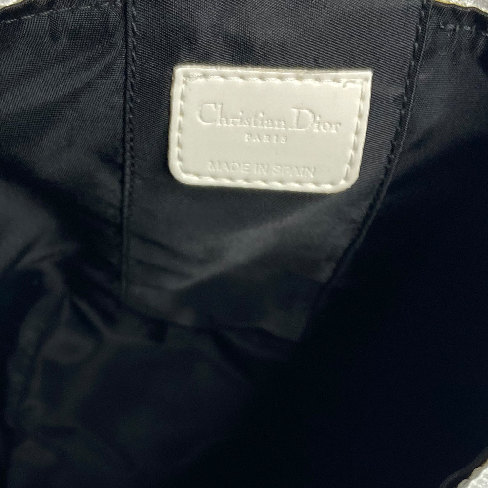 Christian Dior monogram mini vanity case by John Galliano for Dior, 2006. Black and grey monogram canvas rectangular cylinder with white patent piping, No 2 appliqué and top handle. Wrap around silver-tone top zipper closure, black textile interior. Made in Spain