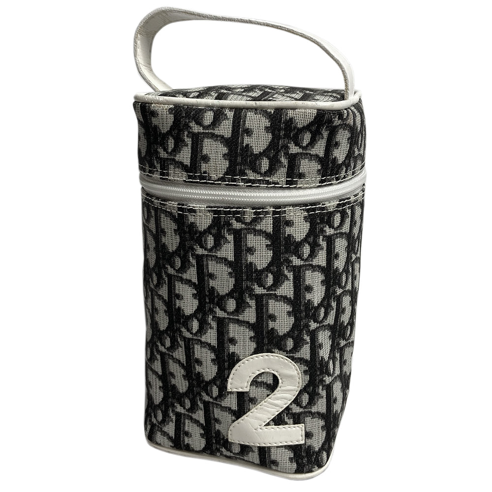 Christian Dior monogram mini vanity case by John Galliano for Dior, 2006. Black and grey monogram canvas rectangular cylinder with white patent piping, No 2 appliqué and top handle. Wrap around silver-tone top zipper closure, black textile interior. Made in Spain