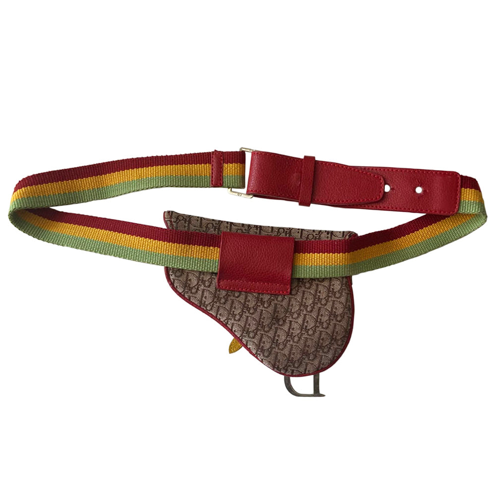 Christian Dior Rasta mini saddle belt waist bag by John Galliano for Dior 2004. Diorissimo canvas with red leather outer piping, yellow & green accent piping, silver-tone hardware. Adjustable canvas webbing & leather belt with 5 hole pin closure. Top flap magnetic snap closure with green & yellow leather straps, CD engraved hanging D, brown satin textile interior.