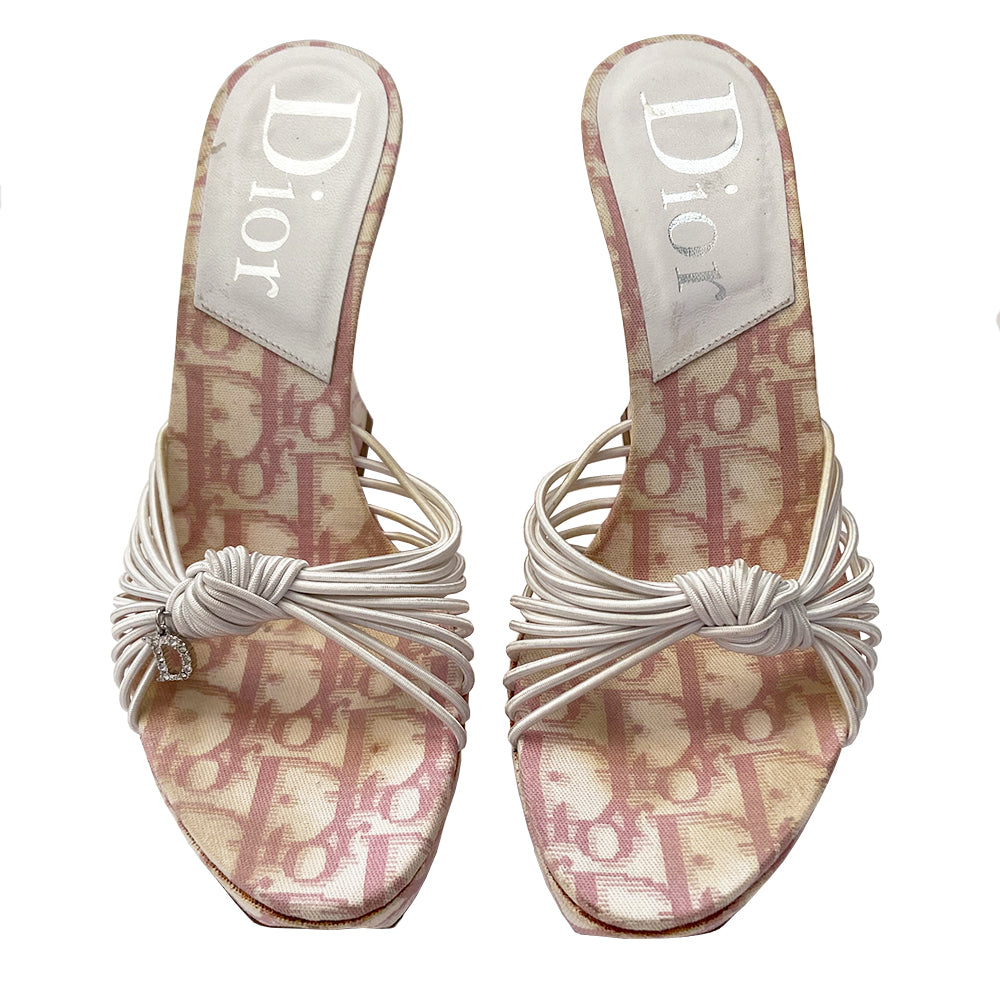 Christian Dior pink monogram canvas Girly wedge slide sandals by John Galliano for Dior circa 2003. 1” platform with curved wedge heels and leather soles. Pink monogram insole with white leather Dior logo heel pad. Multiple white elastic cord strap upper gathered with top knot accent with crystal D logo charm. Made in Italy