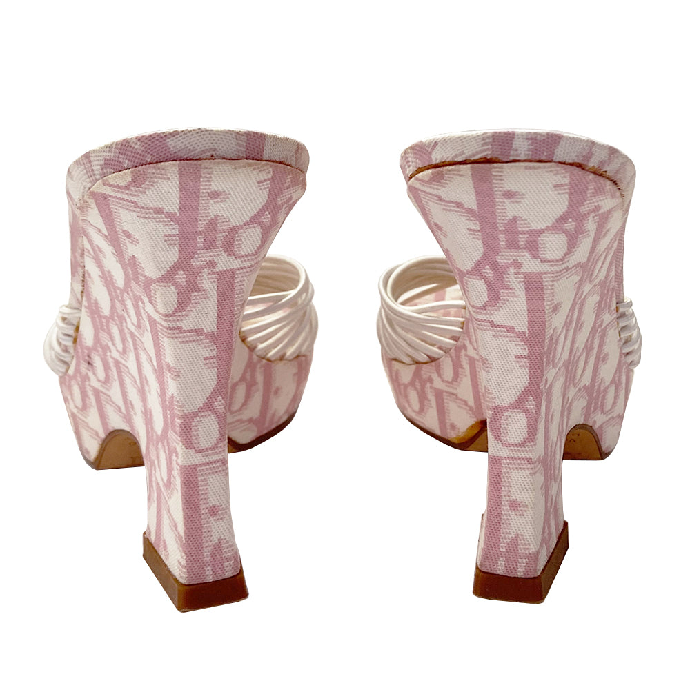 Christian Dior pink monogram canvas Girly wedge slide sandals by John Galliano for Dior circa 2003. 1” platform with curved wedge heels and leather soles. Pink monogram insole with white leather Dior logo heel pad. Multiple white elastic cord strap upper gathered with top knot accent with crystal D logo charm. Made in Italy