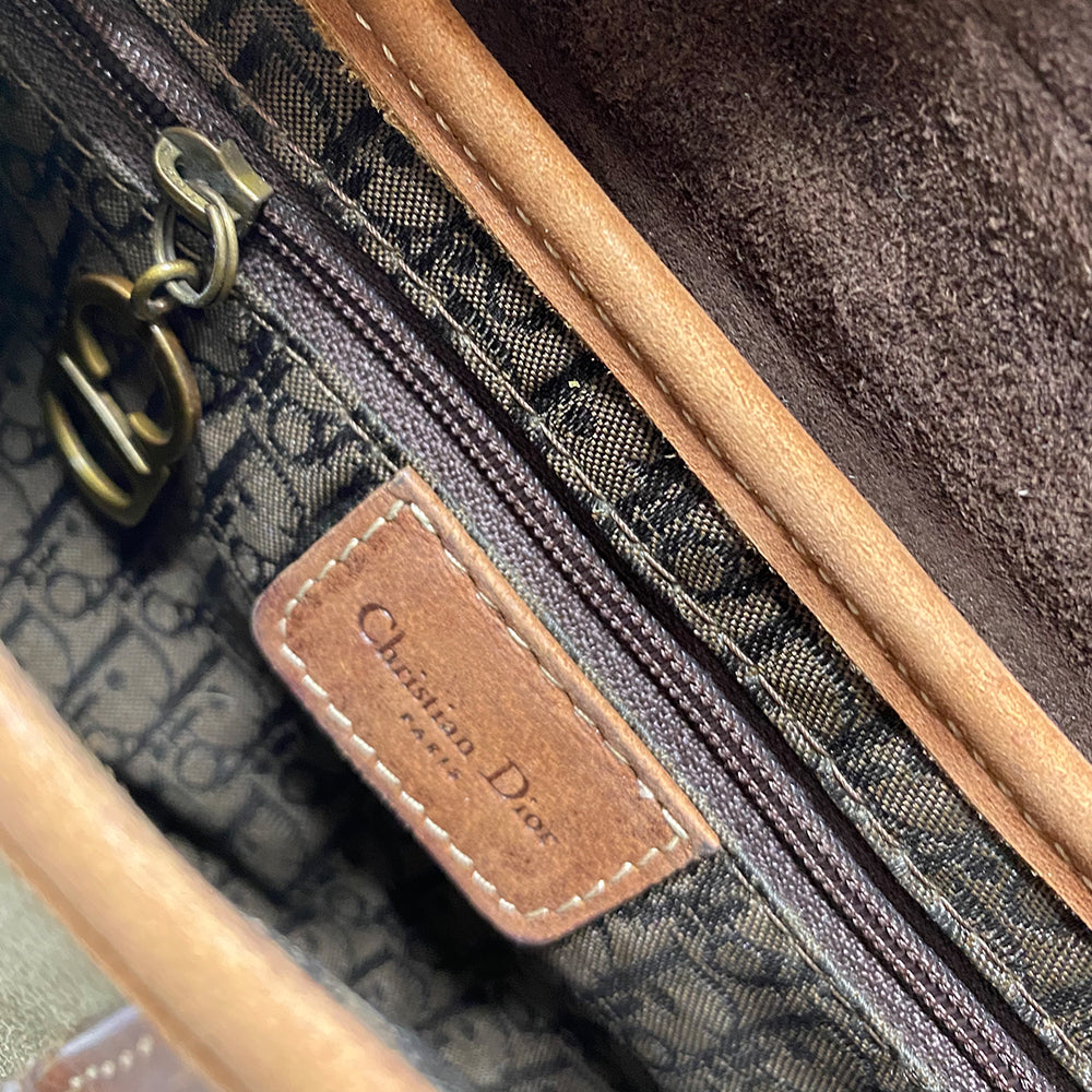 Christian Dior khaki canvas saddle bag by John Galliano for Dior 2002 with burnished gold-tone hardware, brown leather accent. Single flat top leather handle with CD logo adornments at each side. Velcro at flap closure with feature gold-tone D logo. Rear single slip pocket. Black/grey logo textile lined with zip pocket. Made in Italy