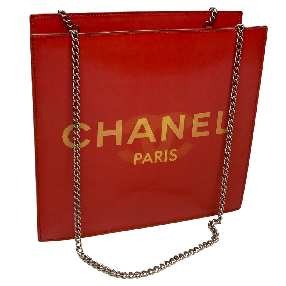 Chanel rectangular vinyl shoulder bag by Karl Lagerfeld for Chanel 2000 with silver-tone double chain shoulder strap and lenticular/holograph design that flip flops between gold-tone interlocking CC logo and CHANEL Paris. Open top, vinyl interior and one zippered pocket with silver-tone Chanel engraved zipper pull. Made in France