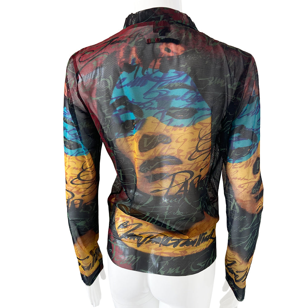 Jean Paul Gaultier face print tattoo mesh top in black, blue, yellow, burgundy by Gaultier Homme, circa 1996 with crew neck long sleeved mesh fabric featuring woman’s face and Jean Paul Gaultier signature on front and back. Yellow accent serge stitching at arms, side seams and neckline. Made in Japan