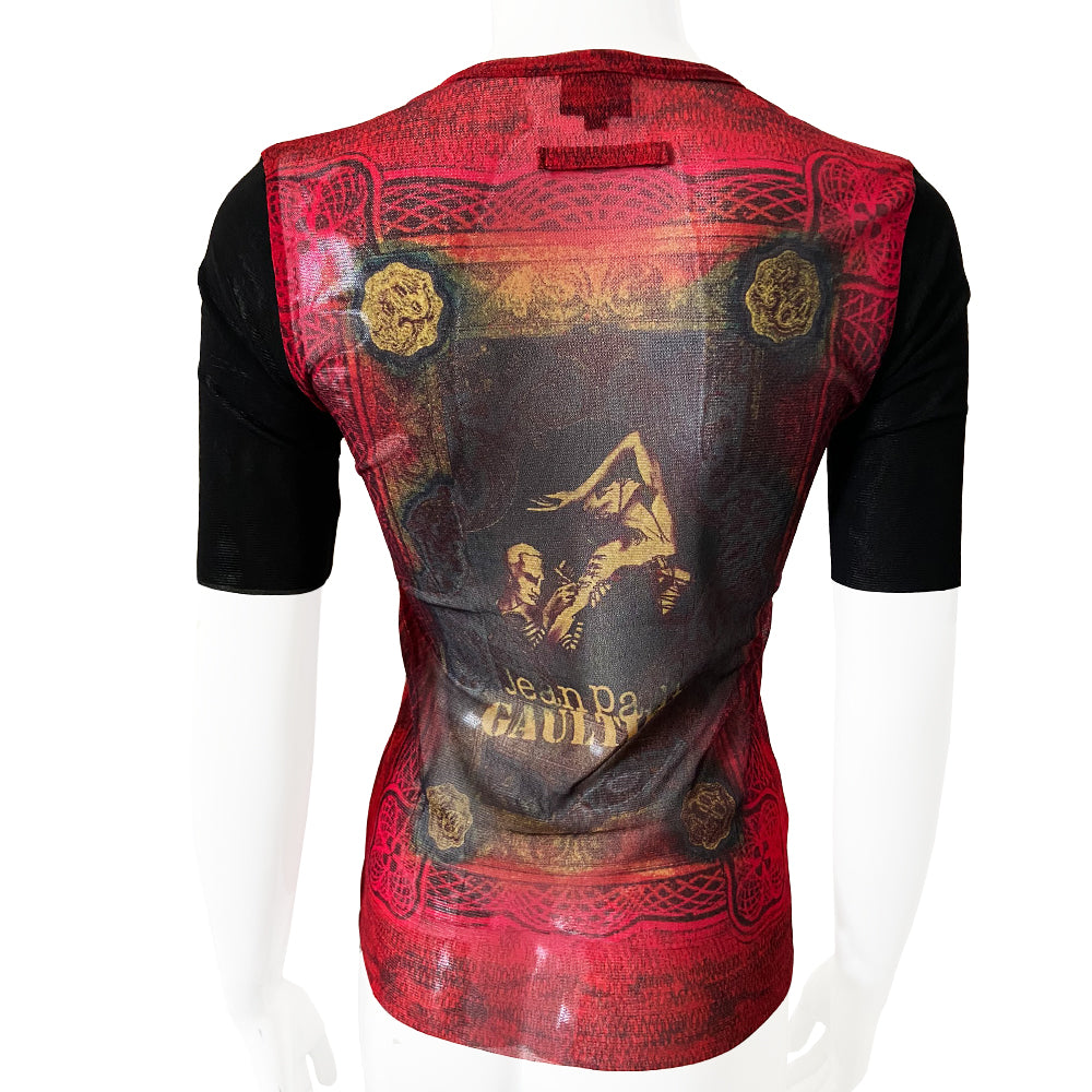 Jean Paul Gaultier tattoo artist 3/4 sleeve mesh top Jean Paul Gaultier Femme circa 1995 featuring Jean Paul Gaultier tattooing a woman’s arm on front and back. Tag size: 40 Main Colors: Red, black sleeves. Made in Japan