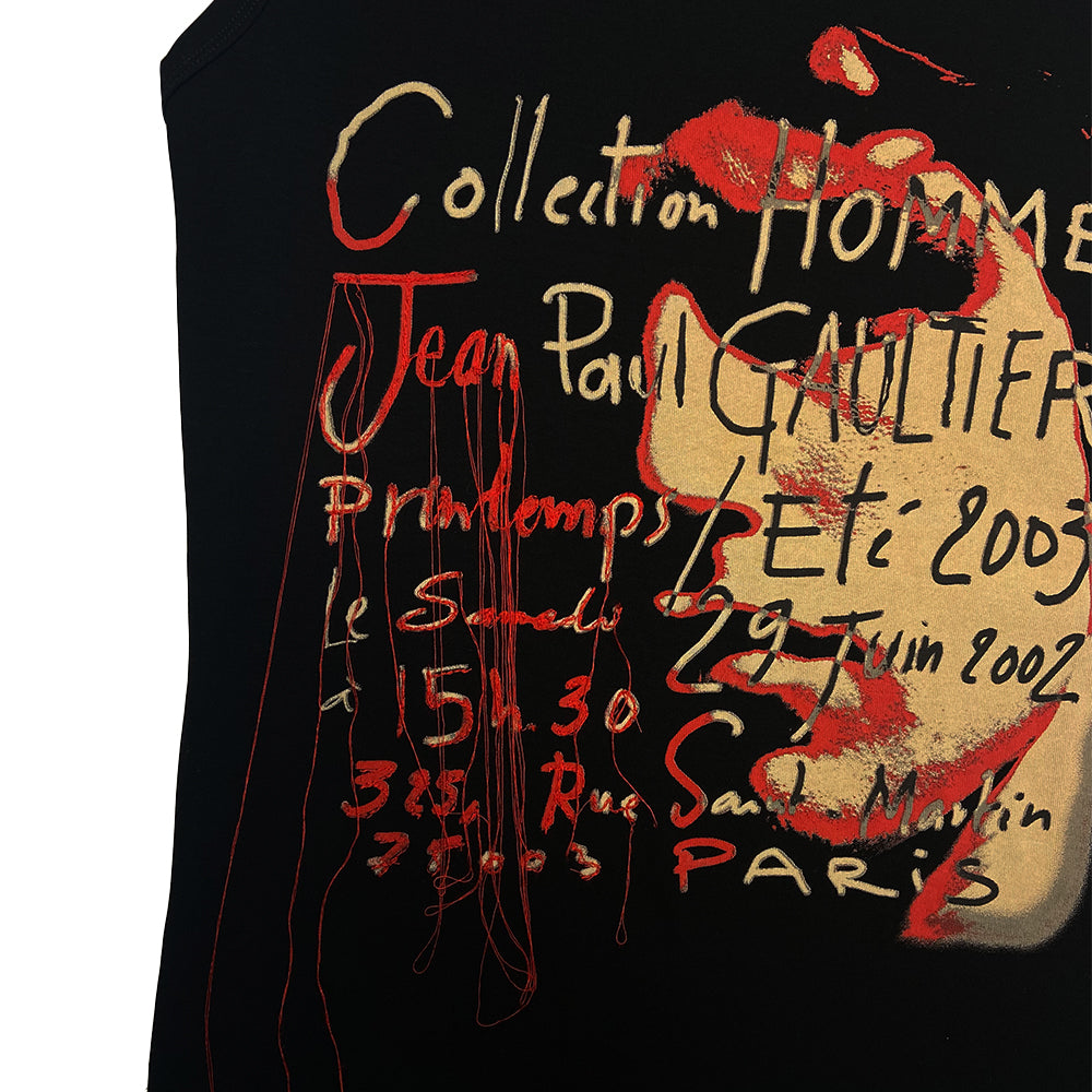 Jean Paul Gaultier face print tank by Jean Paul Gaultier Homme, 2003. Crew neck sleeveless tee with portrait, printed and cursive writing. Tag size: 48 Main Color: Black, red, neutral