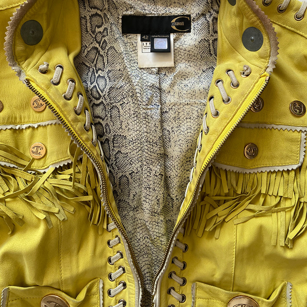 Just Cavalli Acid Yellow Fringe Leather Jacket Circa 2006 in excellent condition. Oversized and small gold-tone logo medallions decoration with whip stitching, fringe and grommets in soft sueded leather. A band of embroidery decorates the bottom hem.