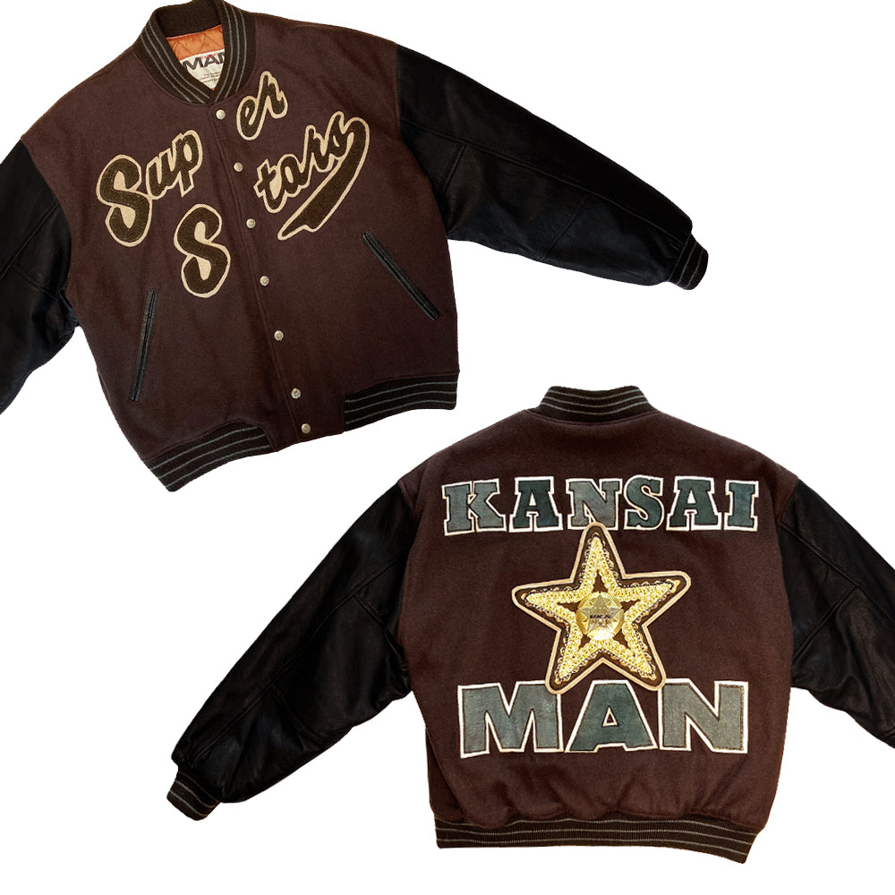 Kansai Man label 1980’s varsity jacket with black leather sleeves and brown wool body, leather accent slash pockets, rib knit collar, cuffs and bottom hem, logo front snap buttons. Super Stars varsity front appliqué lettering, Kansai Man in back with centre star. Full quilted lining, 2 inside slash pockets. Made in Japan