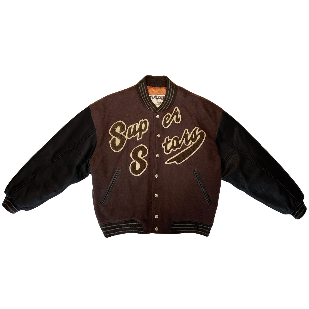 Kansai Man label 1980’s varsity jacket with black leather sleeves and brown wool body, leather accent slash pockets, rib knit collar, cuffs and bottom hem, logo front snap buttons. Super Stars varsity front appliqué lettering, Kansai Man in back with centre star. Full quilted lining, 2 inside slash pockets. Made in Japan