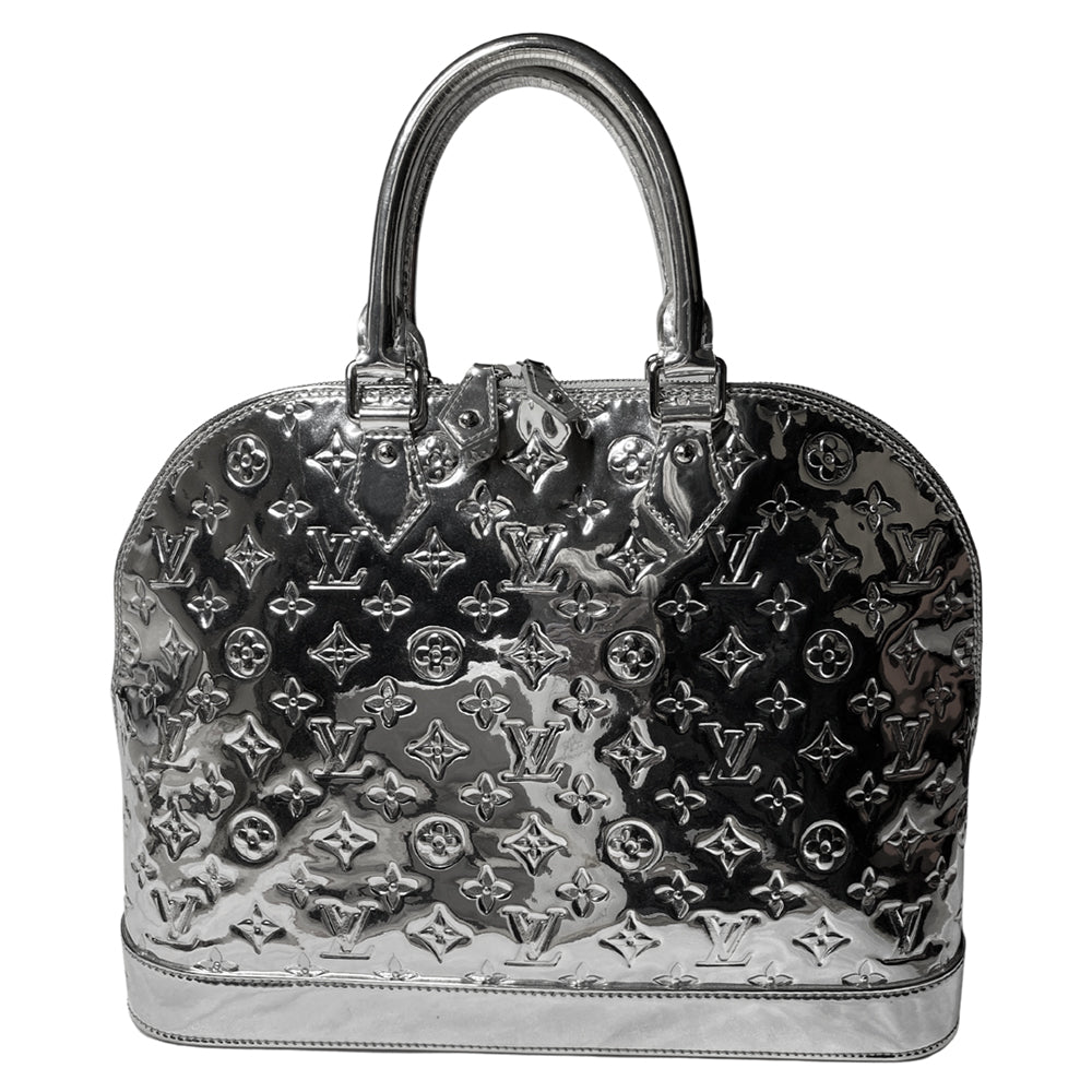 Louis Vuitton mirrored silver-tone monogram embossed vinyl Alma GM bag by Marc Jacobs for Louis Vuitton, 2008 with mirrored silver-tone leather dual handles, trim, bottom with tonal metal feet. Silver-tone top zipper with dual mirrored leather zipper pulls, grey textile interior with open slip and cell phone pocket. Made in France