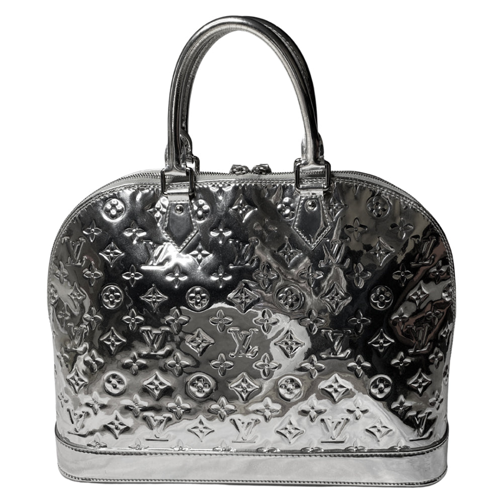 Louis Vuitton mirrored silver-tone monogram embossed vinyl Alma GM bag by Marc Jacobs for Louis Vuitton, 2008 with mirrored silver-tone leather dual handles, trim, bottom with tonal metal feet. Silver-tone top zipper with dual mirrored leather zipper pulls, grey textile interior with open slip and cell phone pocket. Made in France