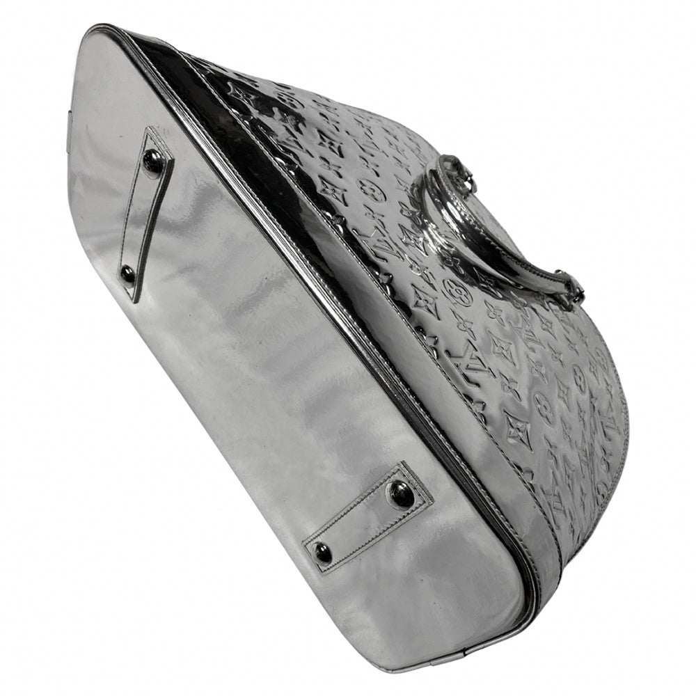 Louis Vuitton mirrored silver-tone monogram embossed vinyl Alma GM bag by Marc Jacobs for Louis Vuitton, 2008 with mirrored silver-tone leather dual handles, trim, bottom with tonal metal feet. Silver-tone top zipper with dual mirrored leather zipper pulls, grey textile interior with open slip and cell phone pocket. Made in France