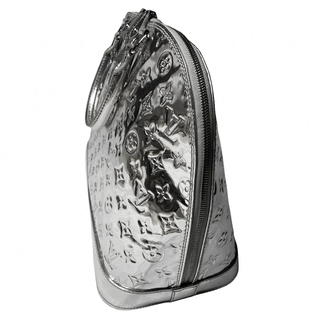 Louis Vuitton mirrored silver-tone monogram embossed vinyl Alma GM bag by Marc Jacobs for Louis Vuitton, 2008 with mirrored silver-tone leather dual handles, trim, bottom with tonal metal feet. Silver-tone top zipper with dual mirrored leather zipper pulls, grey textile interior with open slip and cell phone pocket. Made in France