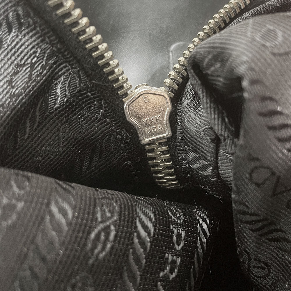 Prada tessuto Shoulder Bag Circa 2000's, black nylon bag with leather handles, front panels and piping, front logo plaque. Zip closure with silver-tone YKK zipper pull opens to black jacquard logo lining, one interior pocket. Made in Italy
