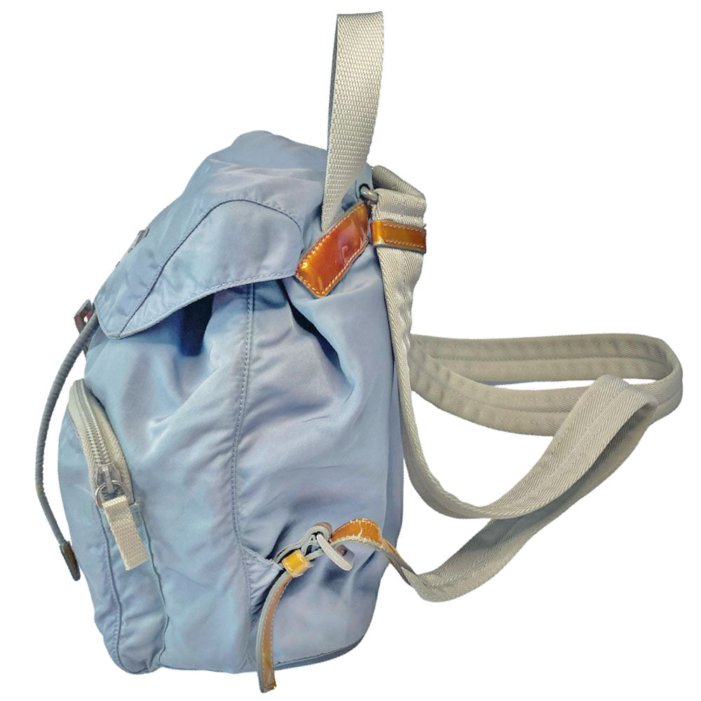 Prada powder blue nylon tessuto drawstring backpack circa 2011, magnetic closure flap with Prada logo plate, 2 zip outer front pockets, brown patent leather strap & accent, silver-tone Prada engraved buckle & drawstring grommets. Adjustable webbing & leather straps. Beige jacquard Prada logo textile lining with interior zip pocket. Made in Italy