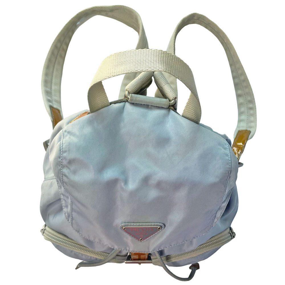 Prada powder blue nylon tessuto drawstring backpack circa 2011, magnetic closure flap with Prada logo plate, 2 zip outer front pockets, brown patent leather strap & accent, silver-tone Prada engraved buckle & drawstring grommets. Adjustable webbing & leather straps. Beige jacquard Prada logo textile lining with interior zip pocket. Made in Italy
