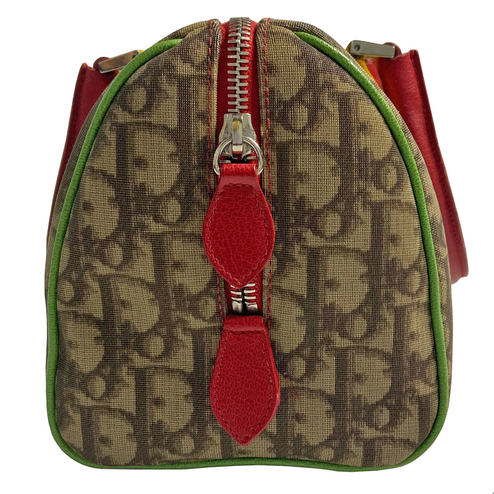 Christian Dior Rasta boston bag by John Galliano for Dior, 2004. Beige and light brown Diorissimo coated canvas with silver-tone hardware, 2 vermillion colored leather rolled top handles, yellow accent leather at base of handles. Yellow leather No 1 in front with red, yellow and green canvas stripe, green piping. Vermillion textile lining with zip pocket, top zip closure. Made in Italy