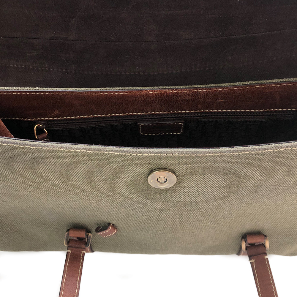 Christian Dior Canvas Saddle Tote by John Galliano. Olive canvas with brown leather handles and sides with front hanging brass logo D, accent stitching throughout. CD stamped brass-tone studs and links. Magnetic button closure. Brown Dior logo satin lining, suede and leather detail and side panels, single zip interior pocket. Brass-tone metal feet.