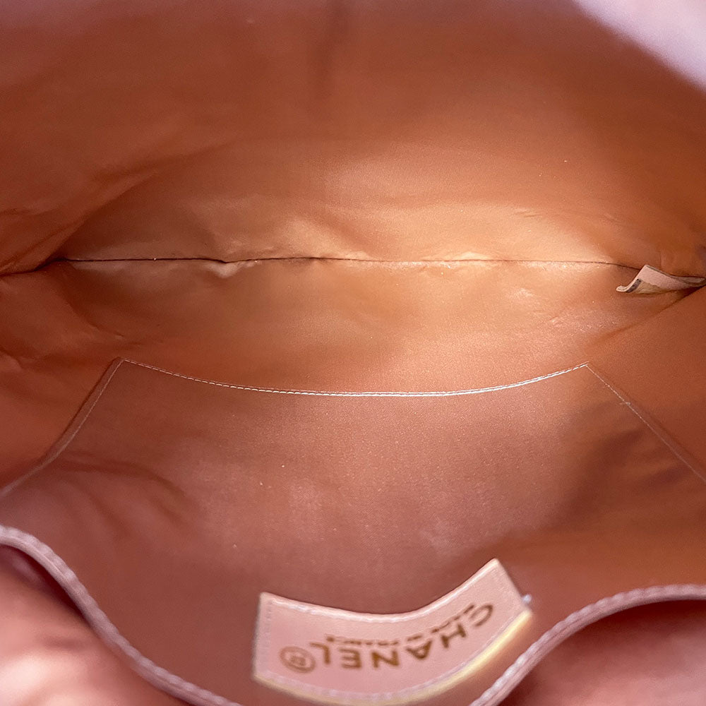 Chanel pink quilted satin and tan suede soft backpack by Karl Lagerfeld for Chanel 2001 with suede drawstring closure, silver-tone Chanel stamped tips and suede straps. Embedded faux pearls spell-out CHANEL embellishment on exterior suede satin interior with single slip pocket. Folds down flat. Made in France 