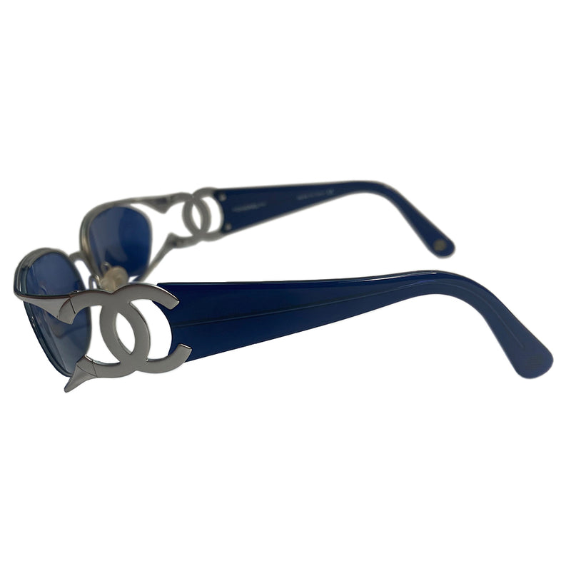 Chanel oval floating blue lens sunglasses by Karl Lagerfeld for Chanel with brushed silver-tone metal frame and cutout side CC logos at temples, thick navy acetate arms Style: 4023 c.135. Made in Italy 