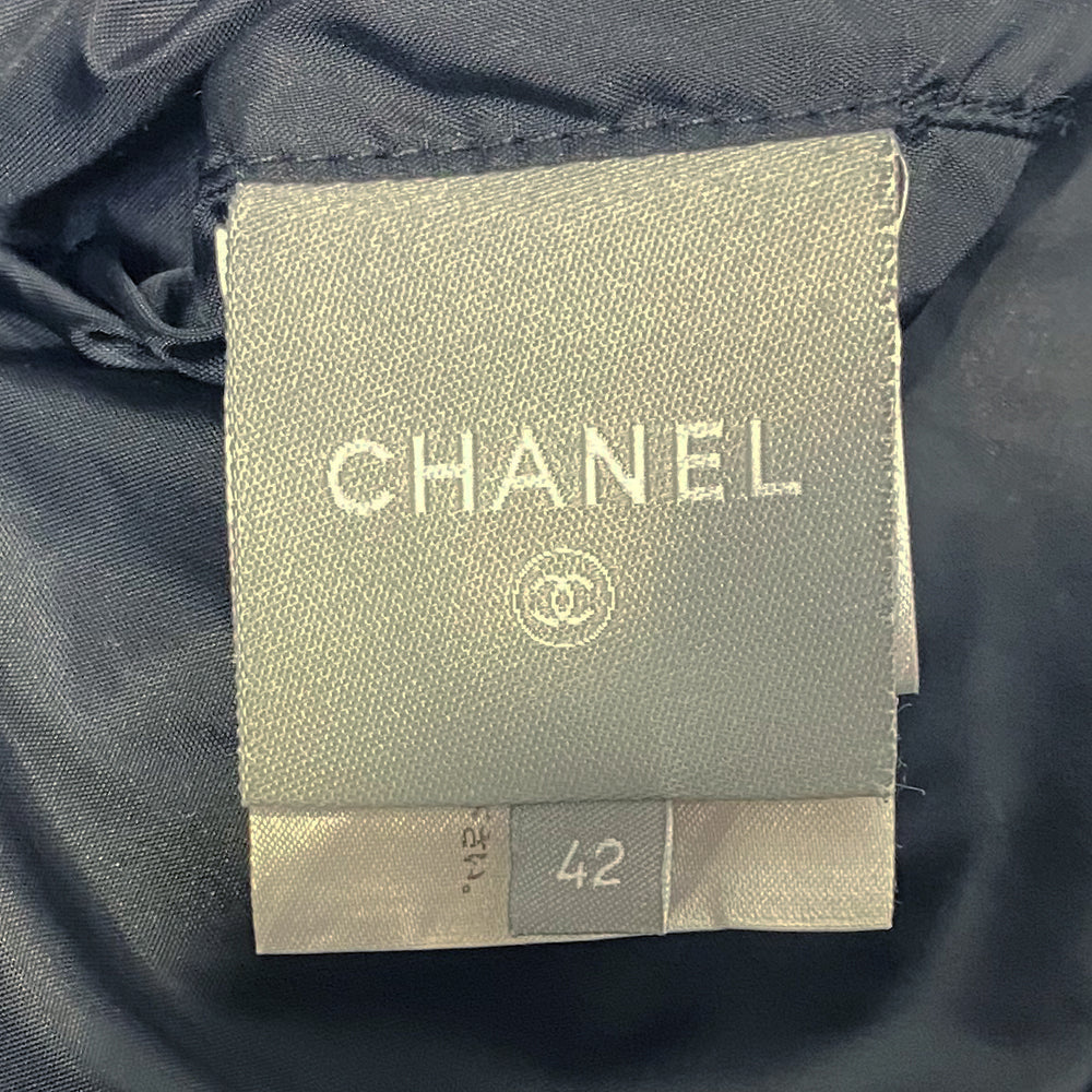 Chanel CC logo long sleeve black satin zip jacket by Karl Lagerfeld for Chanel, AW 2006 with side pockets, rib knit collar and cuffs, lamb leather accent, front zip, 2 buckle closure. CC engraved padlock zipper pull. White appliqué cording accents on front, back and sleeve with embroidered CC box logo, CHANEL in back, metal D-ring. Made in Italy 