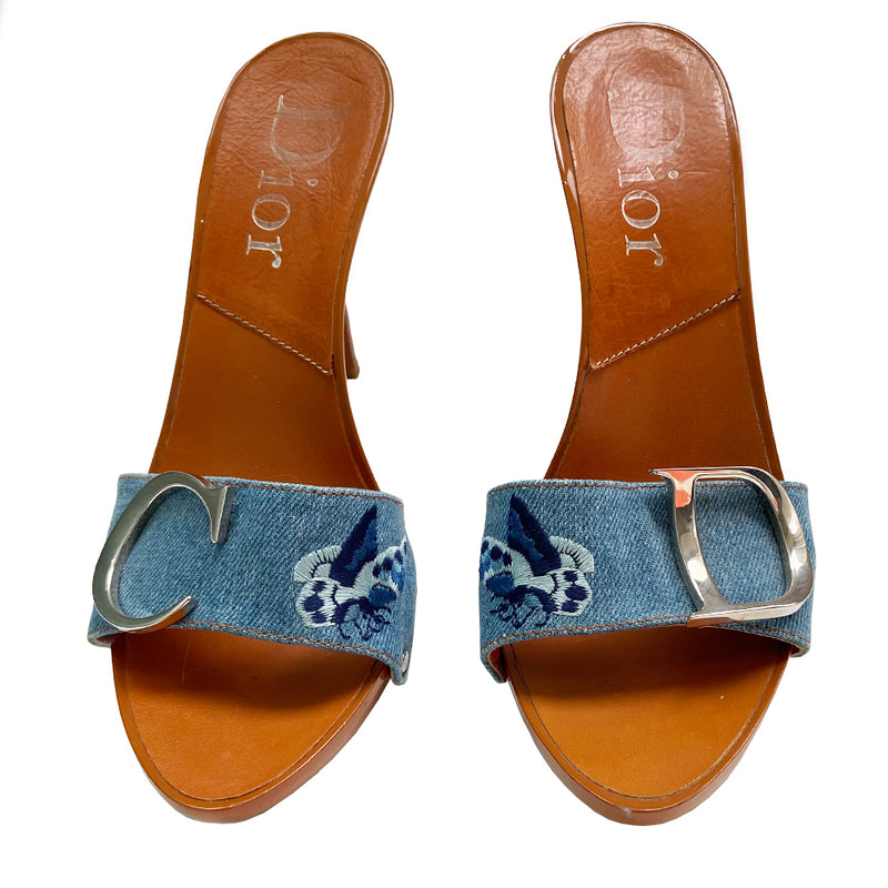 Christian Dior light denim open toe butterfly embroidered slide heels. Denim upper with  embroidered butterfly on each shoe in 3 shades of blue, high gloss caramel color platform and soles with embossed rubber grips. Silver-tone logo initial on each shoe, with silver-tone stud attachments at sides. Made in Italy