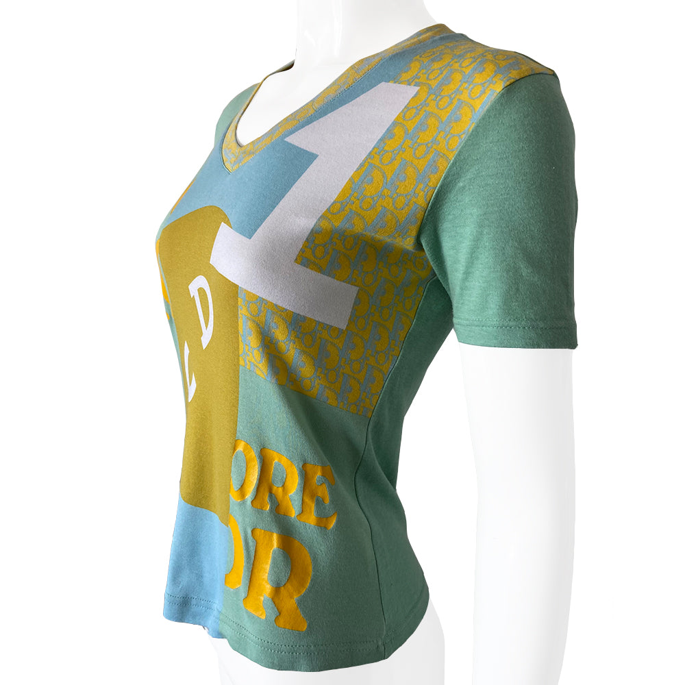 Christian Dior J’Adore Dior short sleeve V neck spring 2005 runway patchwork tee from Japan featuring a patchwork of iconic John Galliano for Dior logo designs through the years Fabric: 100% cotton.  Color: Main: Turquoise and blue Fabric: 100% cotton Size: FR 38 Made in Portugal 