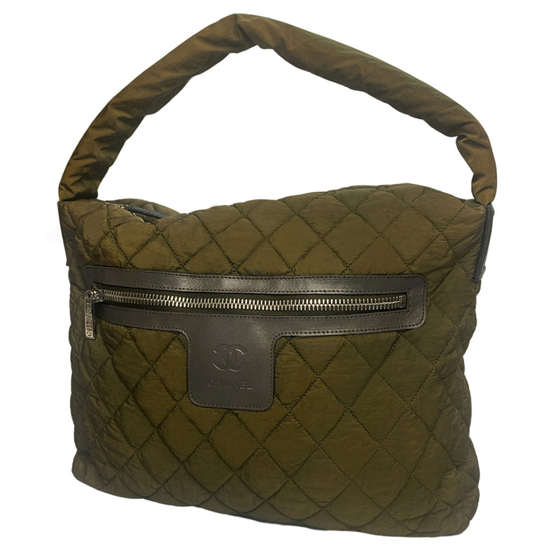 Chanel lightweight quilted green nylon shoulder bag by Karl Lagerfeld for Chanel, 2009/2010 with brown CC embossed brown leather accents at strap ends & around exterior silver-tone logo engraved outer pocket zipper. Interlocking CC stitched bottom logo. Zip top closure with red nylon interior, one zip pocket. Made in Italy 
