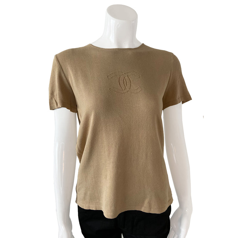 Chanel Tan color Short Sleeved Knit Top Interlocking with CC logo woven into fabric in front. Small repair to right shoulder, visually minimal while wearing. Short sleeves with round neck in fine rib knit of 100% cotton. Color: Tan Size: FR 44 Made in France 