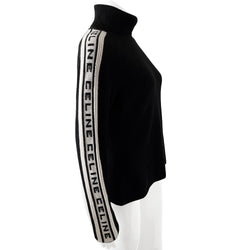 Celine cashmere logo sleeve turtleneck sweater from F/W 1999. Black ribbed high neck with long narrow sleeves and CELINE logo stripe in white and black running from cuff to neck on each arm. Fabric: 100% Cashmere. Size: L Made in Italy.  