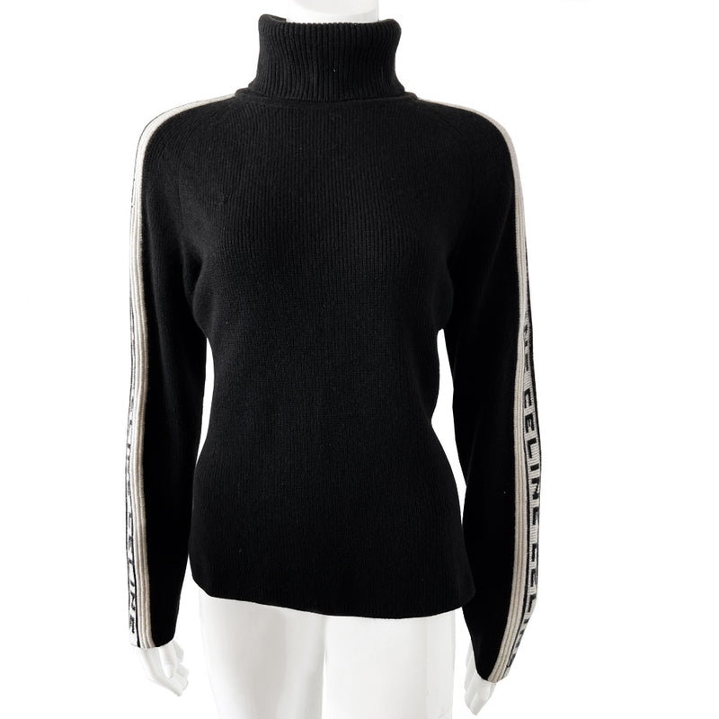 Celine cashmere logo sleeve turtleneck sweater from F/W 1999. Black ribbed high neck with long narrow sleeves and CELINE logo stripe in white and black running from cuff to neck on each arm. Fabric: 100% Cashmere. Size: L Made in Italy.  