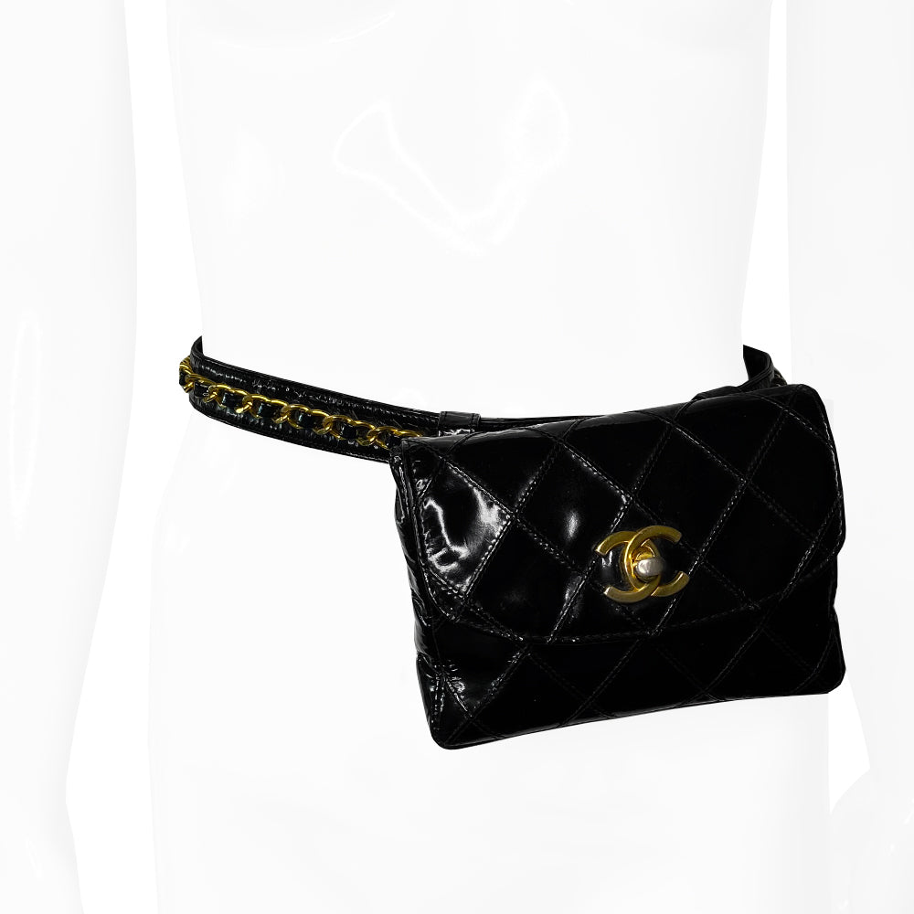 Chanel black quilted patent leather flap belt bag by Karl Lagerfeld for Chanel with gold tone turnlock closure and woven gold chain attached to adjustable belt. Black leather interior with single zip pocket. Indicated belt size: 70cm / 28 Included: Original boutique sticker and guarantee cards. Made in Italy 
