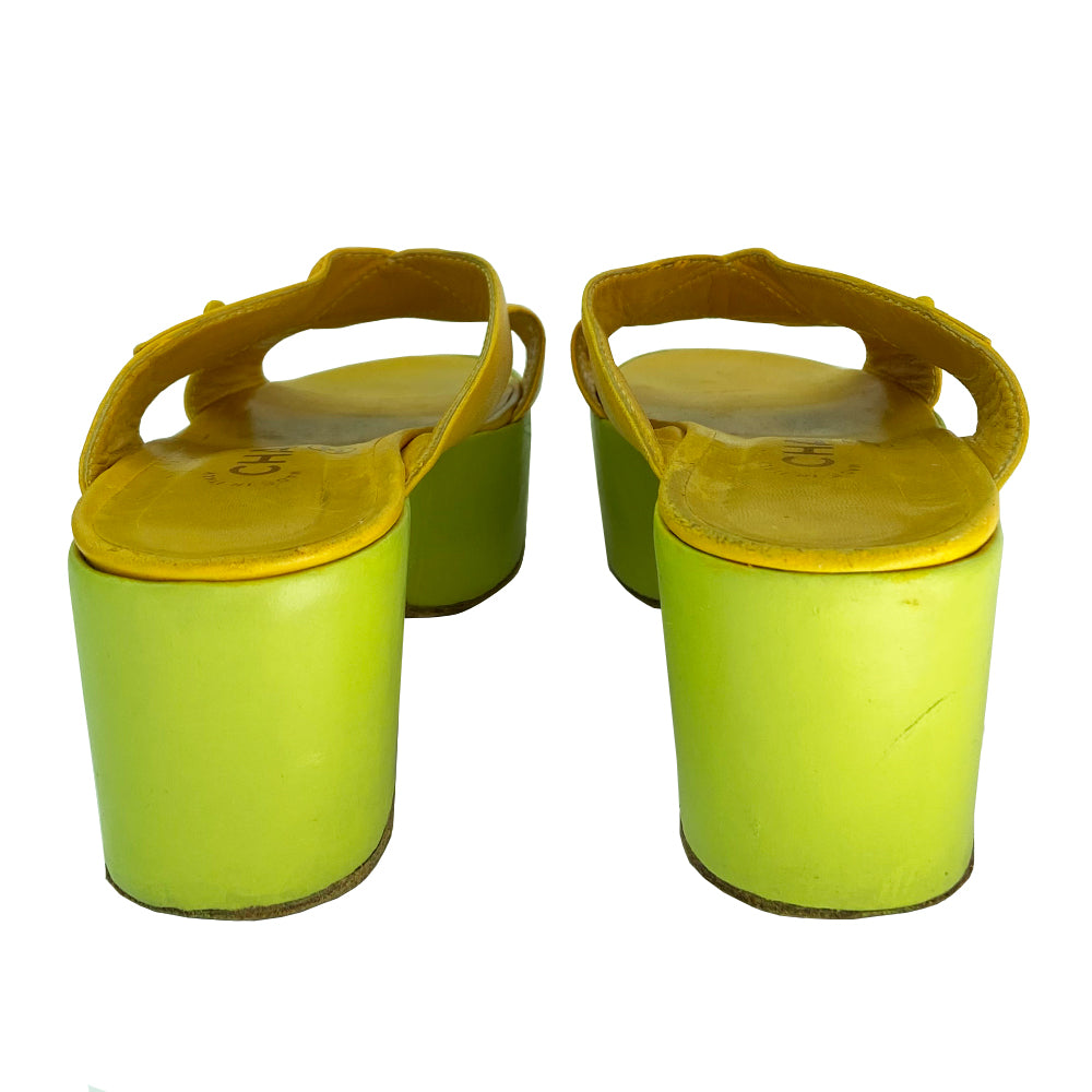 Chanel Lemon-Lime two tone lamb leather platform open toe slip on sandals circa 2002.  2” platform with small heel. Bright yellow criss-cross upper with tonal accent stitching and signature Mademoiselle lock adornment and lime green platform. Size: IT 38 Some visible scuffing. Made in Italy 
