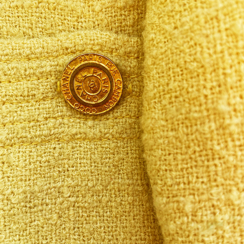 Chanel Boucle Jacket and Skirt Suit circa 1980’s in very good condition Jacket: Long sleeved with 4 pockets in front embellished with gold Chanel Rue Cambon logo buttons, 3 buttons at sleeves Skirt: Back invisible zipper with hook at waistband Size - Tag is hand written, seems to be FR: 42, fits like a medium Fabric: Main: 100%, Lining: 100% Silk Color: pale yellow Made in France