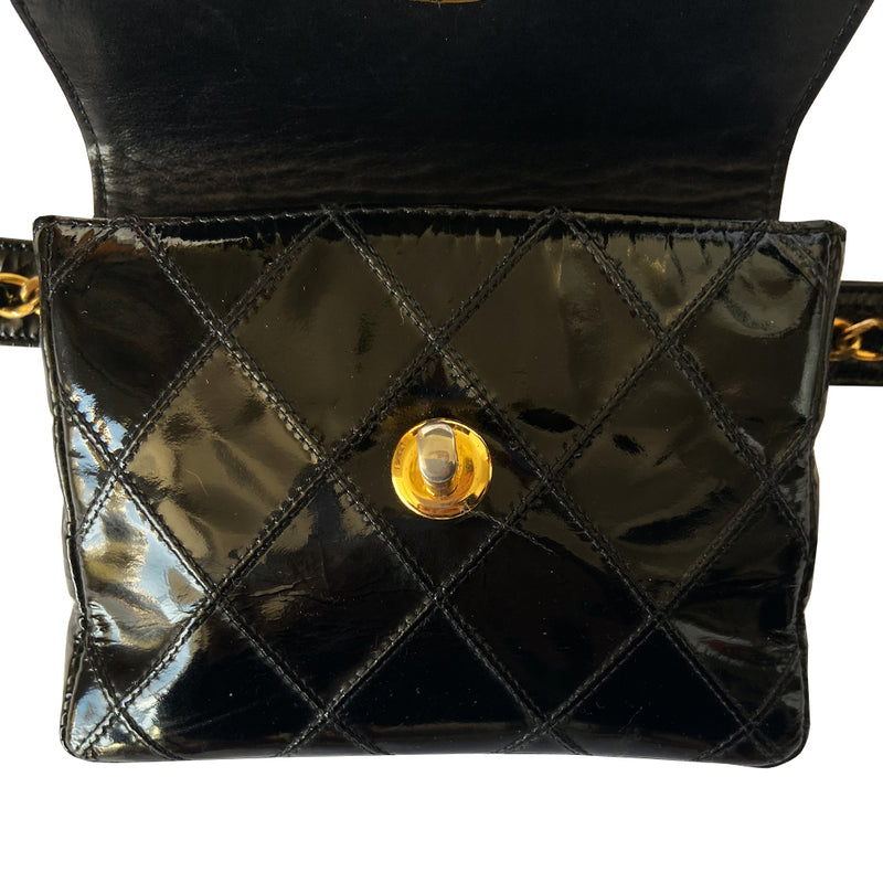 Chanel black quilted patent leather flap belt bag by Karl Lagerfeld for Chanel with gold tone turnlock closure and woven gold chain attached to adjustable belt. Black leather interior with single zip pocket. Indicated belt size: 70cm / 28 Included: Original boutique sticker and guarantee cards. Made in Italy 