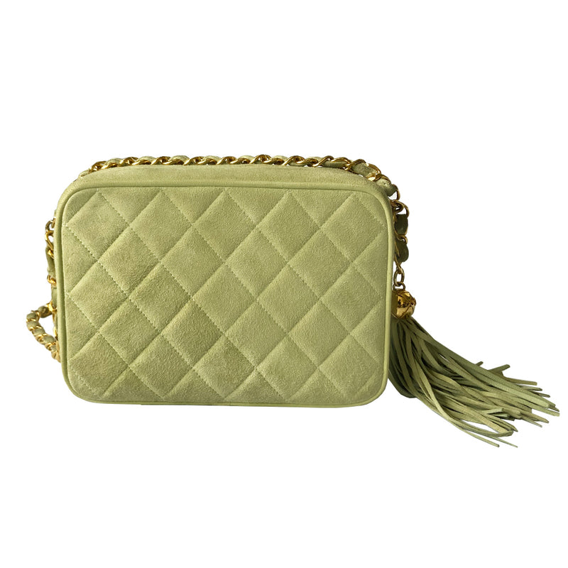 Chanel suede camera bag by Karl Lagerfeld for Chanel, 1991-94. Pistachio color quilted suede, top zipper, etched gold ball and tassels zipper pull, suede and gold chain shoulder strap. Outer flap pocket with engraved gold CC turn-lock, tonal leather lining, patch slip and zippered pocket with gold zipper pull. Made in France 
