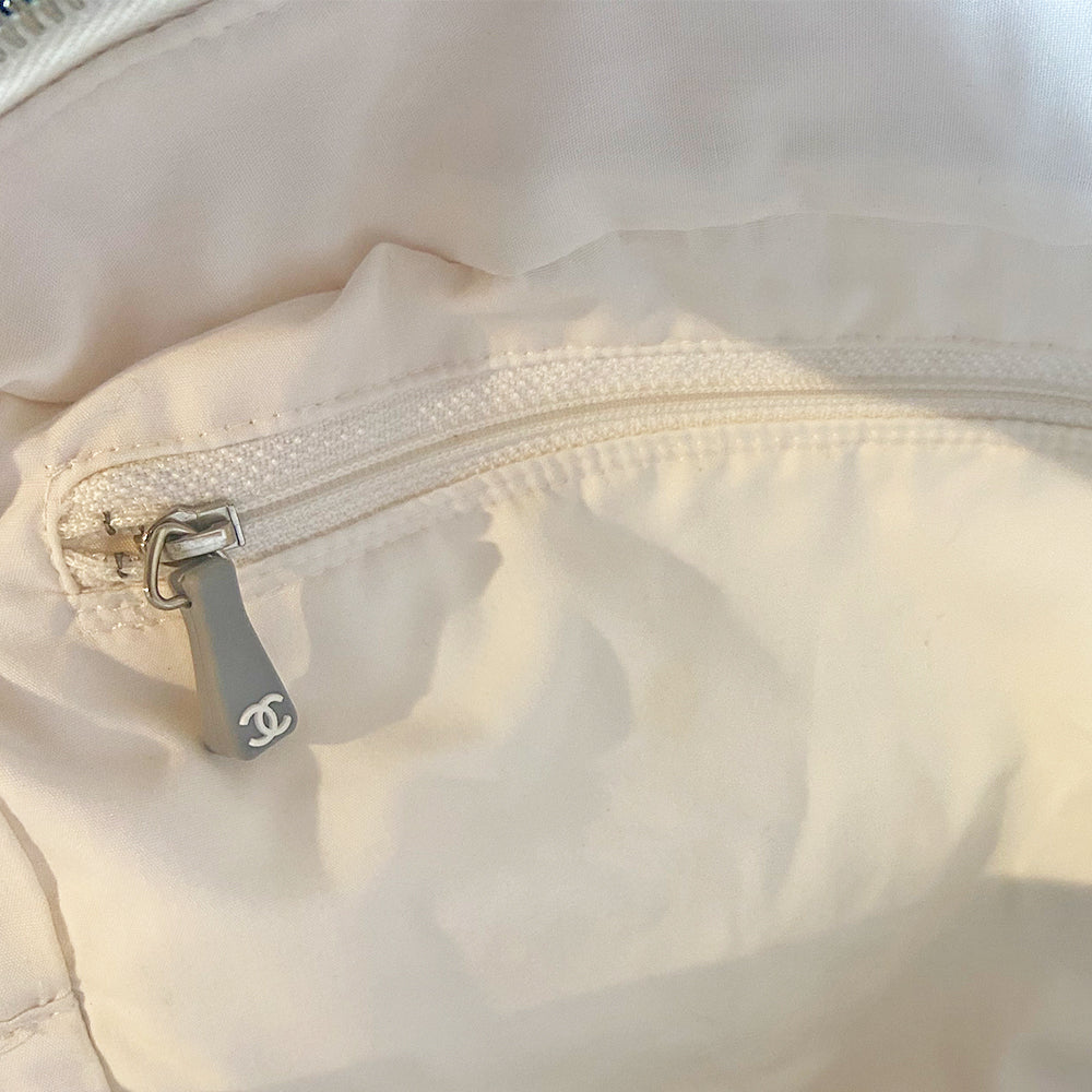Chanel Logo white canvas quilted bowler by Karl Lagerfeld for Chanel 2001 with rolled leather handles, leather piping and grey leather, front CHANEL logo letters. Silver-tone top zip closure with CC logo grey rubber zipper pulls, Chanel logo rubber protective feet. White textile lining, one open leather pocket. Made in Italy