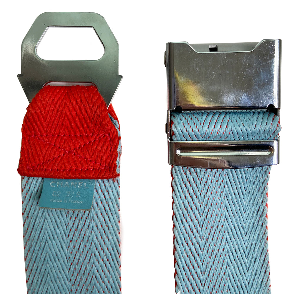 Pale Blue & Red Sport CC Logo Silver Buckle Belt from Spring/Summer 2002 Sport Line. Slight scratch on the buckle. Chevron pattern woven fabric belt that slides through brushed silver-tone interlocking CC logo clip buckle closure. Adjustable size Color: Pale blue and red. Made in France. Total L (in) 34" W (in) 2"