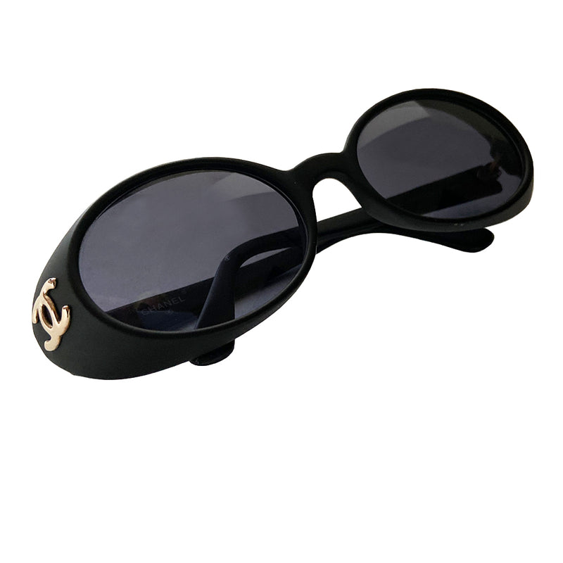 Chanel 1990’s oval goggle sunglasses by Karl Lagerfeld for Chanel. Oval goggle style acetate frames with dark charcoal lenses, interlocking CC gold logos at temple Frame Color: Flat black Style: 05976 Case included Condition: Excellent with no scratches on lens or frame, case in good condition Made in Italy