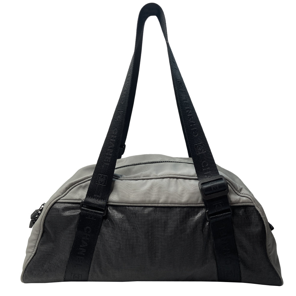 Chanel Sport bi-color grey canvas and black textured rubber canvas duffle/travel bag by Karl Lagerfeld for Chanel 2003/2004 with double zip closure, boxed rubber CC front logo. Double Chanel embossed adjustable satin webbing logo carry straps, logo padlock style black rubber zipper pulls, black nylon lining with single zip pocket. Made in Italy