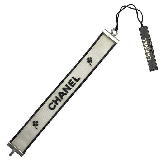 Chanel rubber bracelet by Karl Lagerfeld for Chanel, Autumn 2001 with translucent with black edges tinted rubber bracelet with CHANEL printed out and 2 clovers at each end in black. Silver-tone end caps and hook closure, Chanel hallmark makers mark stamp. Made in France 