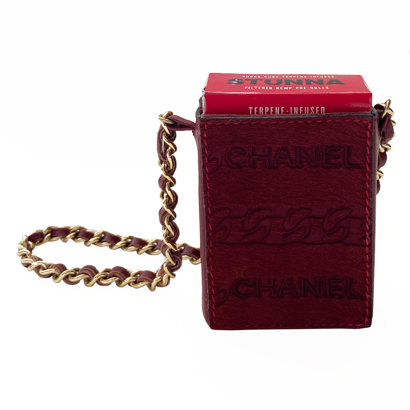 Chanel burgundy pony & lamb leather cigarette case by Karl Lagerfeld for Chanel, circa 2000-2002. Open top mini pouch with CHANEL and interlocking chain design engraved into the  pony hair panel on one side, red contrast stitching. Intertwined leather with gold-tone chain. Chanel logo interior stamp. Made in Italy 