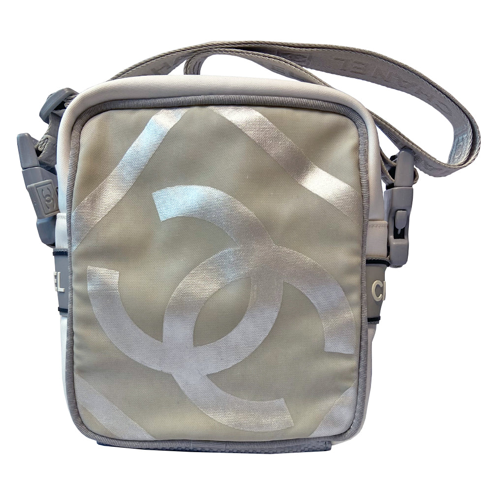 Chanel grey with silver Sport Line nylon canvas rectangular cross body messenger bag by Karl Lagerfeld for Chanel, 2001 with angled box front CC logo, rubber CHANEL side logos, grey piping and long sating webbing logo removable shoulder strap. Top ziper with grey textile interior and inside slip pocket. Made in Italy 