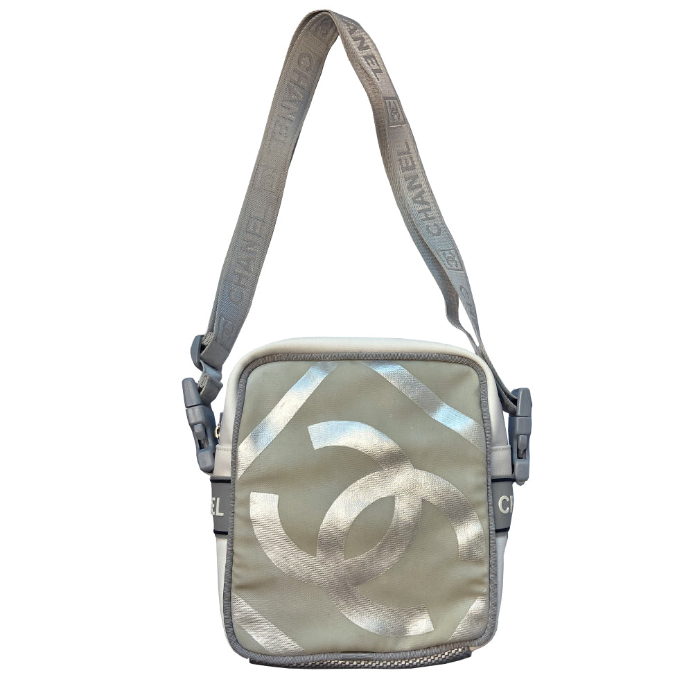 Chanel grey with silver Sport Line nylon canvas rectangular cross body messenger bag by Karl Lagerfeld for Chanel, 2001 with angled box front CC logo, rubber CHANEL side logos, grey piping and long sating webbing logo removable shoulder strap. Top ziper with grey textile interior and inside slip pocket. Made in Italy 