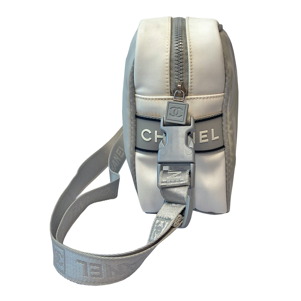 Chanel grey with silver Sport Line nylon canvas rectangular cross body messenger bag by Karl Lagerfeld for Chanel, 2001 with angled box front CC logo, rubber CHANEL side logos, grey piping and long sating webbing logo removable shoulder strap. Top ziper with grey textile interior and inside slip pocket. Made in Italy 