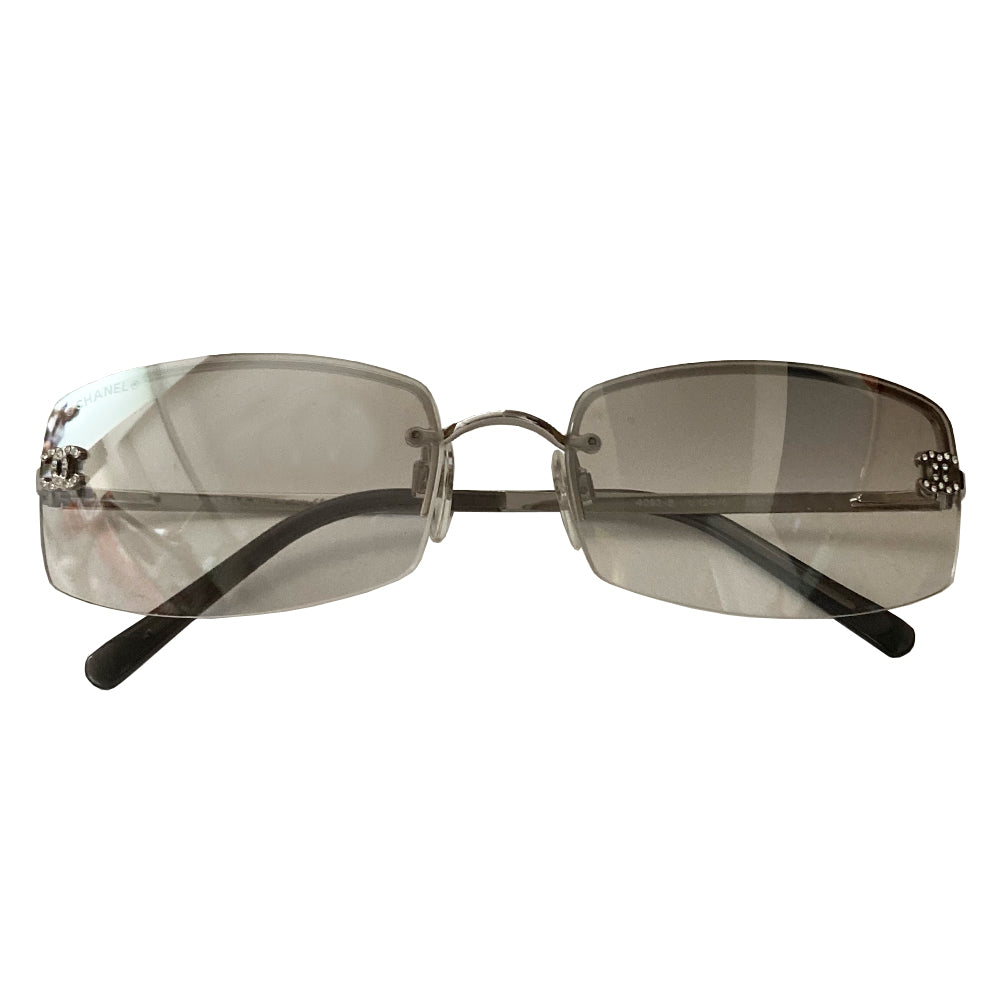 Chanel clear lens crystal CC logo sunglasses with curved rectangle shape, silver-tone metal frame on upper lens and frameless on the bottom with grey to clear lenses, interlocking crystal CC logo at each lens, Chanel engraved nose pad.  Style: 4093-B Excellent condition, with no scratch on lenses. Made in Italy 