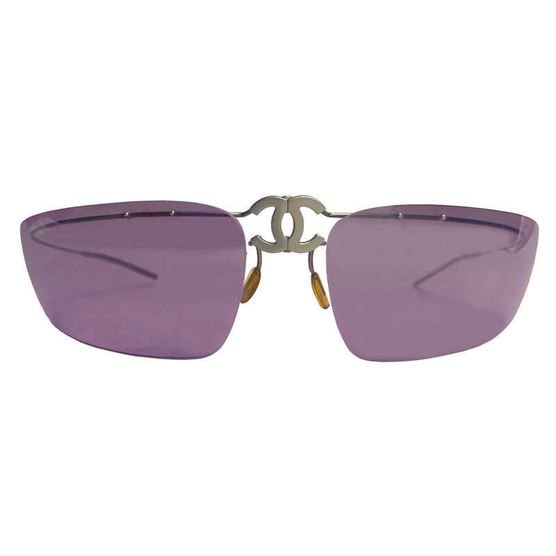 Chanel CC logo folding rimless wrap sunglasses by Karl Lagerfeld for Chanel, 1990’s. Continuous silver-tone wrap around wire top frame and arms attached to purple tinted lenses with center folding hinge at CC logo nose bridge. Model: 4032 Chanel soft case included. Made in Italy 